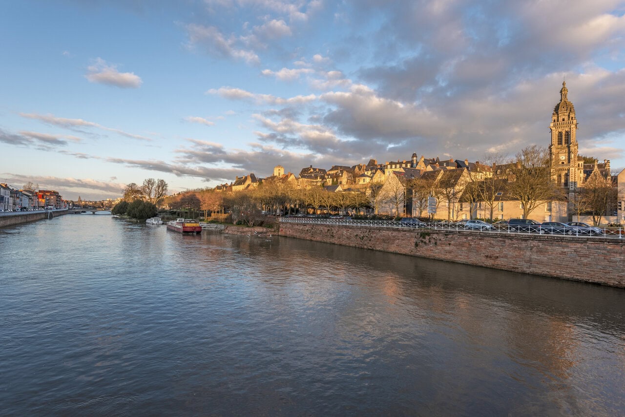 The Sarthe River and historic skyline of Le Mans at sunset, France.