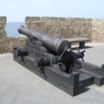 Historic cannon on Alghero city walls overlooking the sea