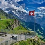 Swiss Alps ski resort with mountain railway and Swiss flag, reached by transfers from Basel Airport