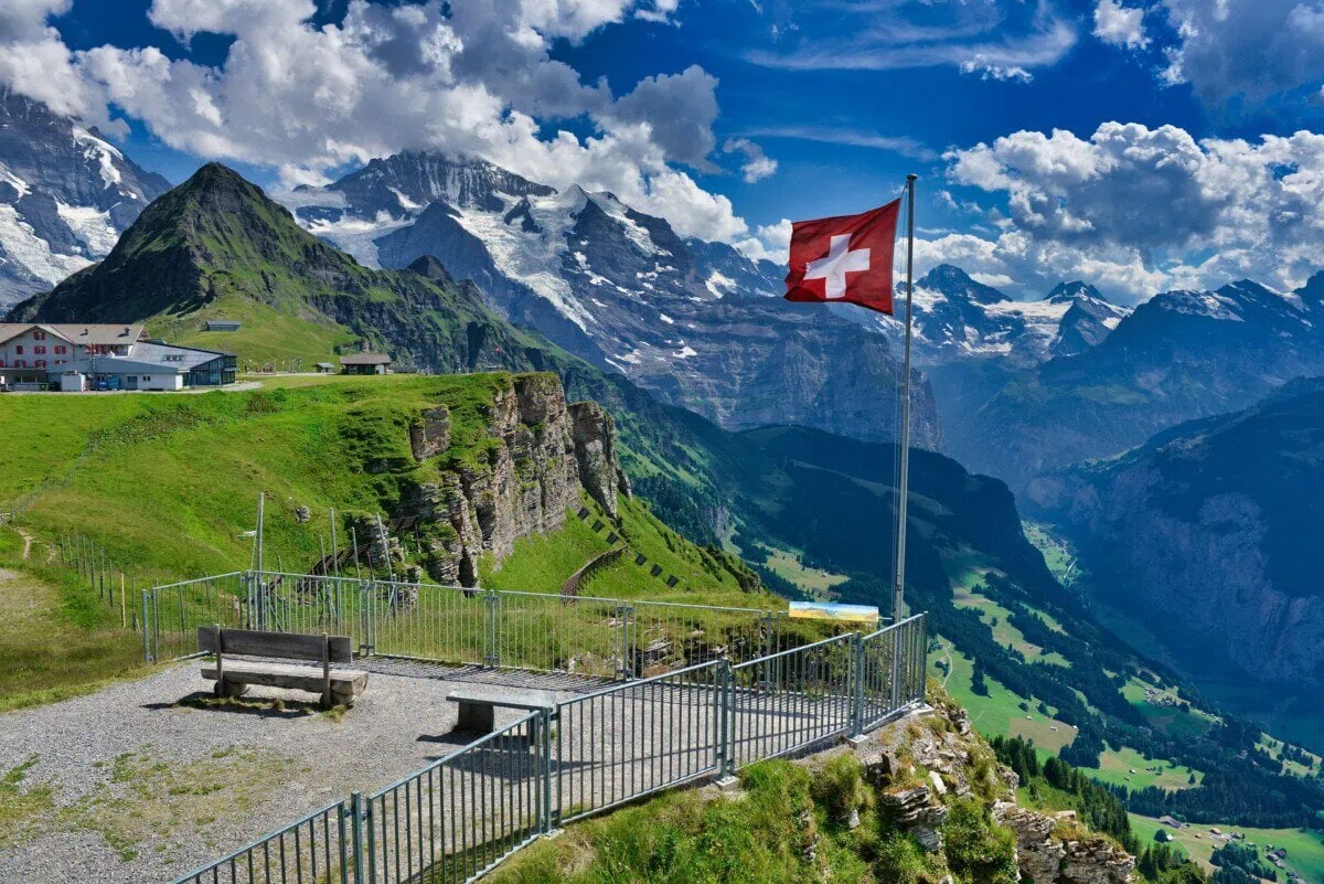 Swiss Alps ski resort with mountain railway and Swiss flag, reached by transfers from Basel Airport