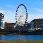 Düsseldorf Rhine waterfront with the Schlossturm and a large Ferris wheel beside the river