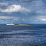 Ferry sailing off the coast near Copenhagen under a dramatic blue sky