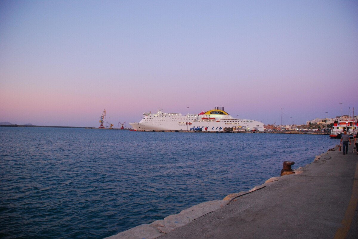 Large passenger ferry docked at a Greek port serving Crete at dusk