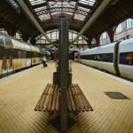 Passenger trains standing at covered platforms inside Copenhagen Central Station