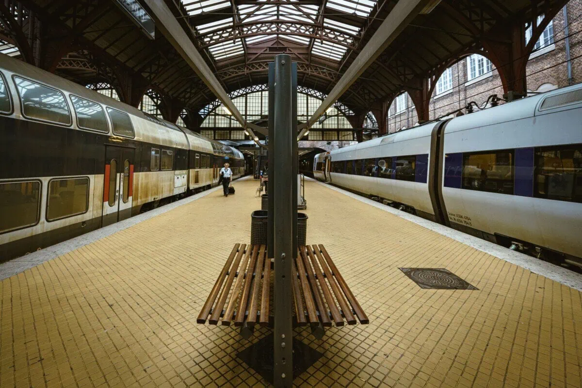 Passenger trains standing at covered platforms inside Copenhagen Central Station
