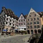 Half-timbered houses and historic buildings on a cobbled square in Nuremberg