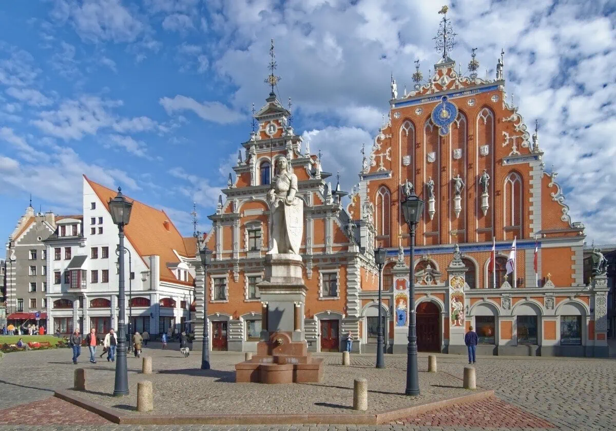 House of the Black Heads and Roland statue in Riga Town Hall Square under a blue sky