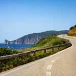 Coastal road winding beside cliffs and the sea in Sardinia