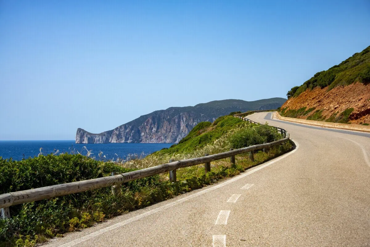 Coastal road winding beside cliffs and the sea in Sardinia