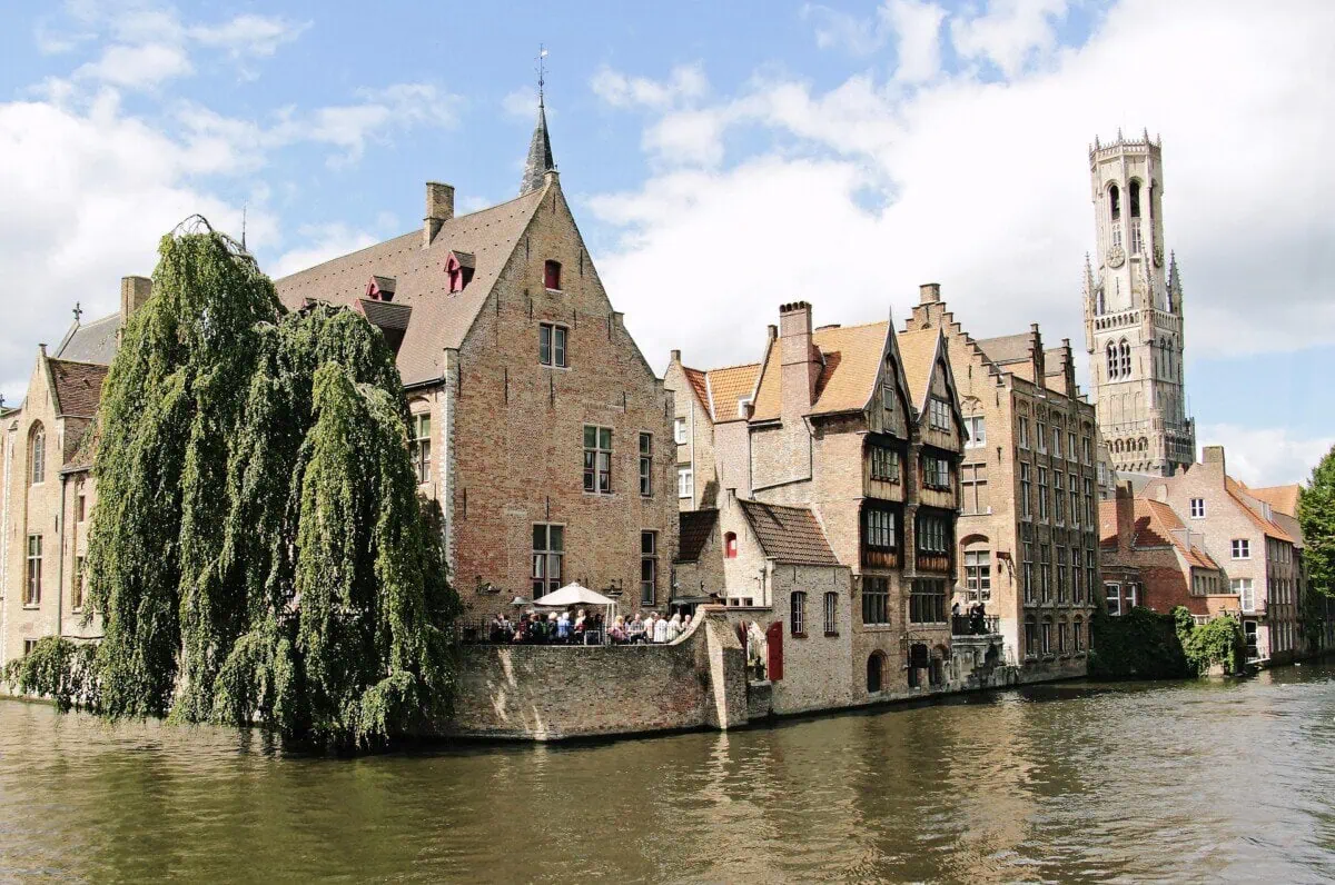 Historic buildings beside a Bruges canal with the Belfry visible in the background