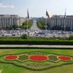 View across central Bucharest and Piața Constituției with the Romanian flag and city boulevards