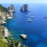 Faraglioni sea stacks and boats in the blue Mediterranean off Capri
