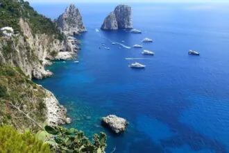 Faraglioni sea stacks and boats in the blue Mediterranean off Capri