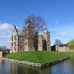 Rosenborg Castle in Copenhagen surrounded by lawns, trees and a moat