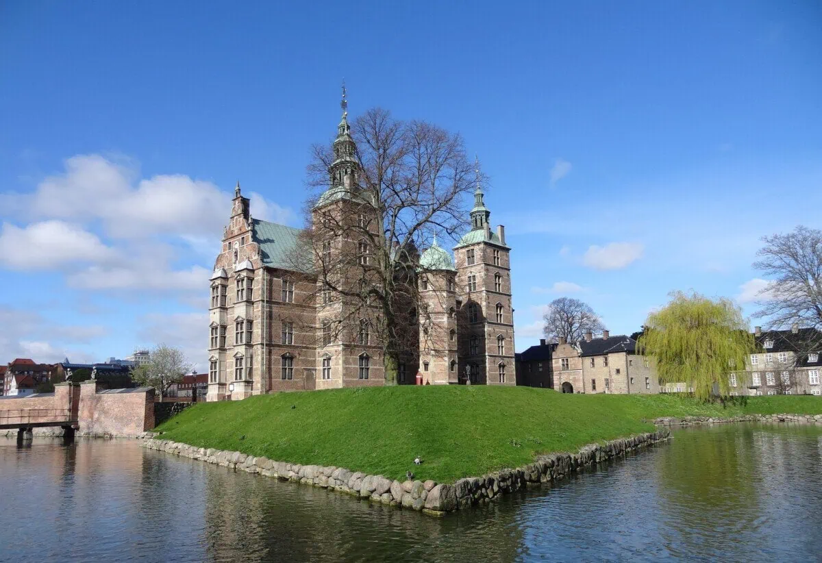 Rosenborg Castle in Copenhagen surrounded by lawns, trees and a moat
