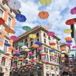 Colourful umbrellas suspended above a historic street in Genoa