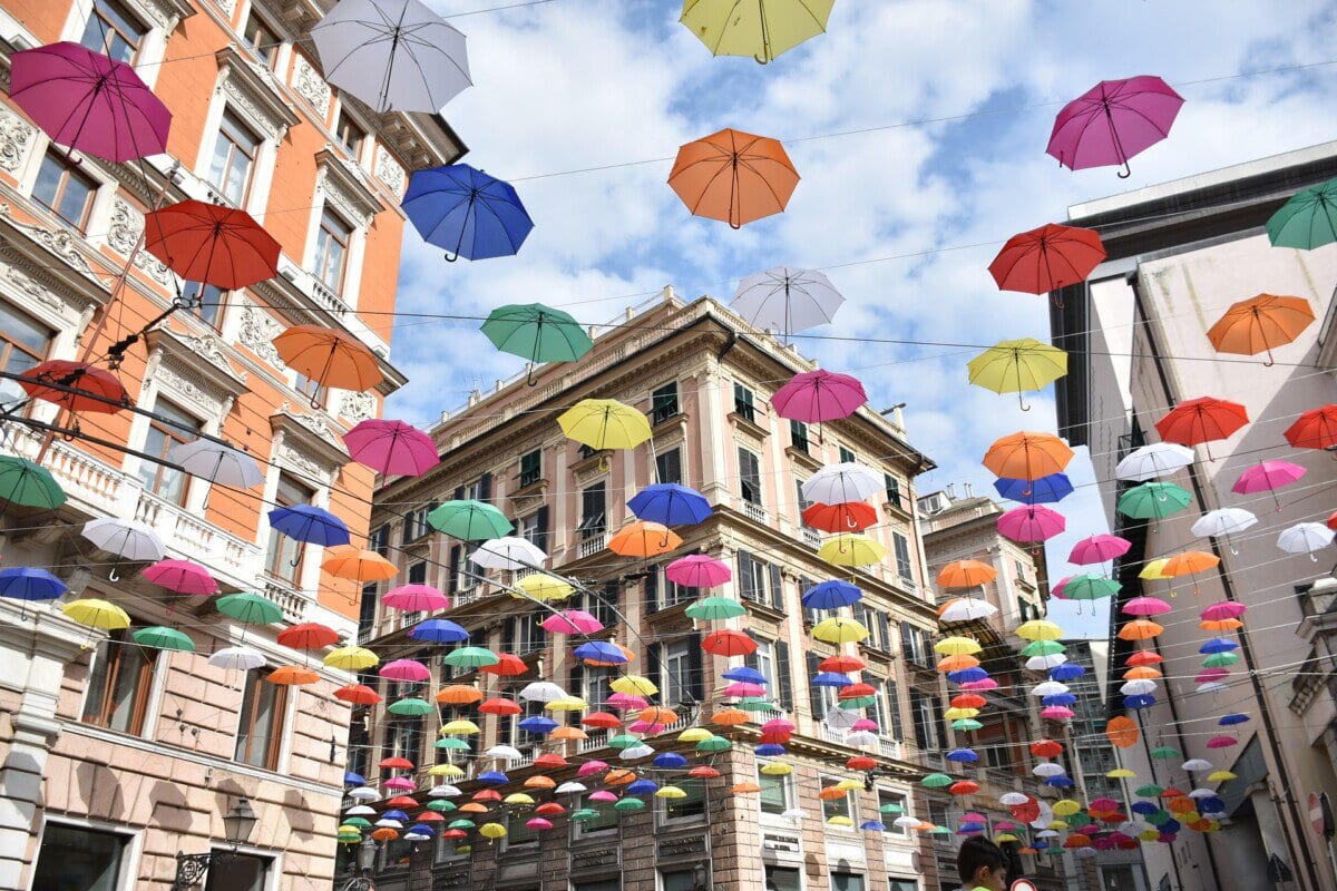Colourful umbrellas suspended above a historic street in Genoa