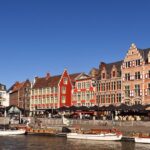 Historic guild houses and sightseeing boats beside the river in central Ghent