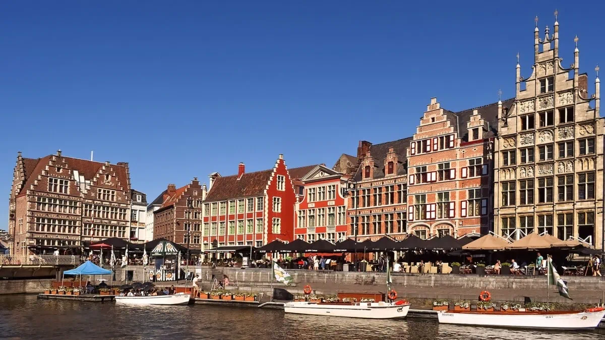Historic guild houses and sightseeing boats beside the river in central Ghent