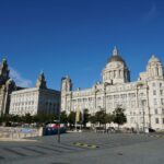 Liverpool waterfront with the Royal Liver Building, Cunard Building and Port of Liverpool Building under a blue sky