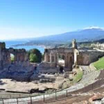 Ancient Greek theatre in Taormina overlooking the coast and snow-capped Mount Etna