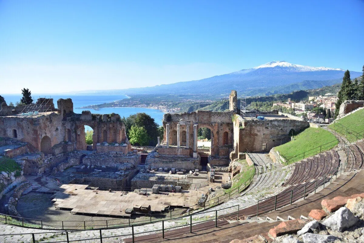 Ancient Greek theatre in Taormina overlooking the coast and snow-capped Mount Etna