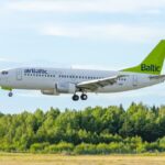 airBaltic passenger aircraft flying over woodland