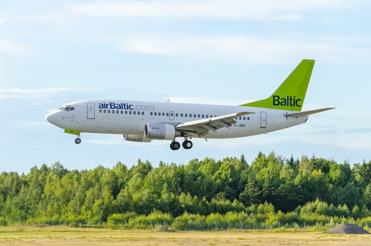 airBaltic passenger aircraft flying over woodland