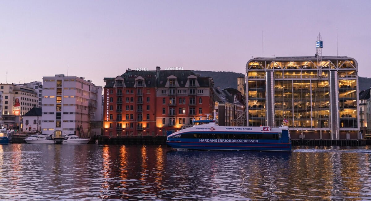 Fjord cruise boat passing the waterfront in Tromsø at dusk
