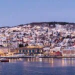 Snow-covered Tromsø waterfront and hillside homes in northern Norway