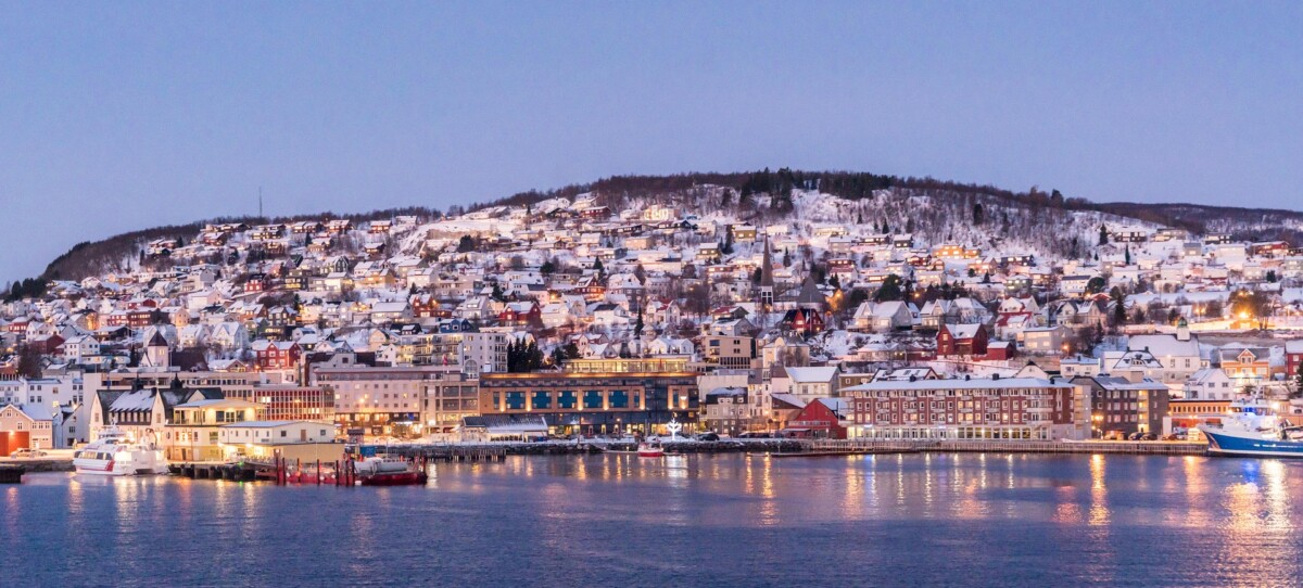 Snow-covered Tromsø waterfront and hillside homes in northern Norway